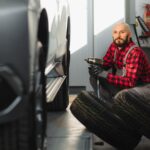 Mechanik zmienia oponę samochodową w warsztacie