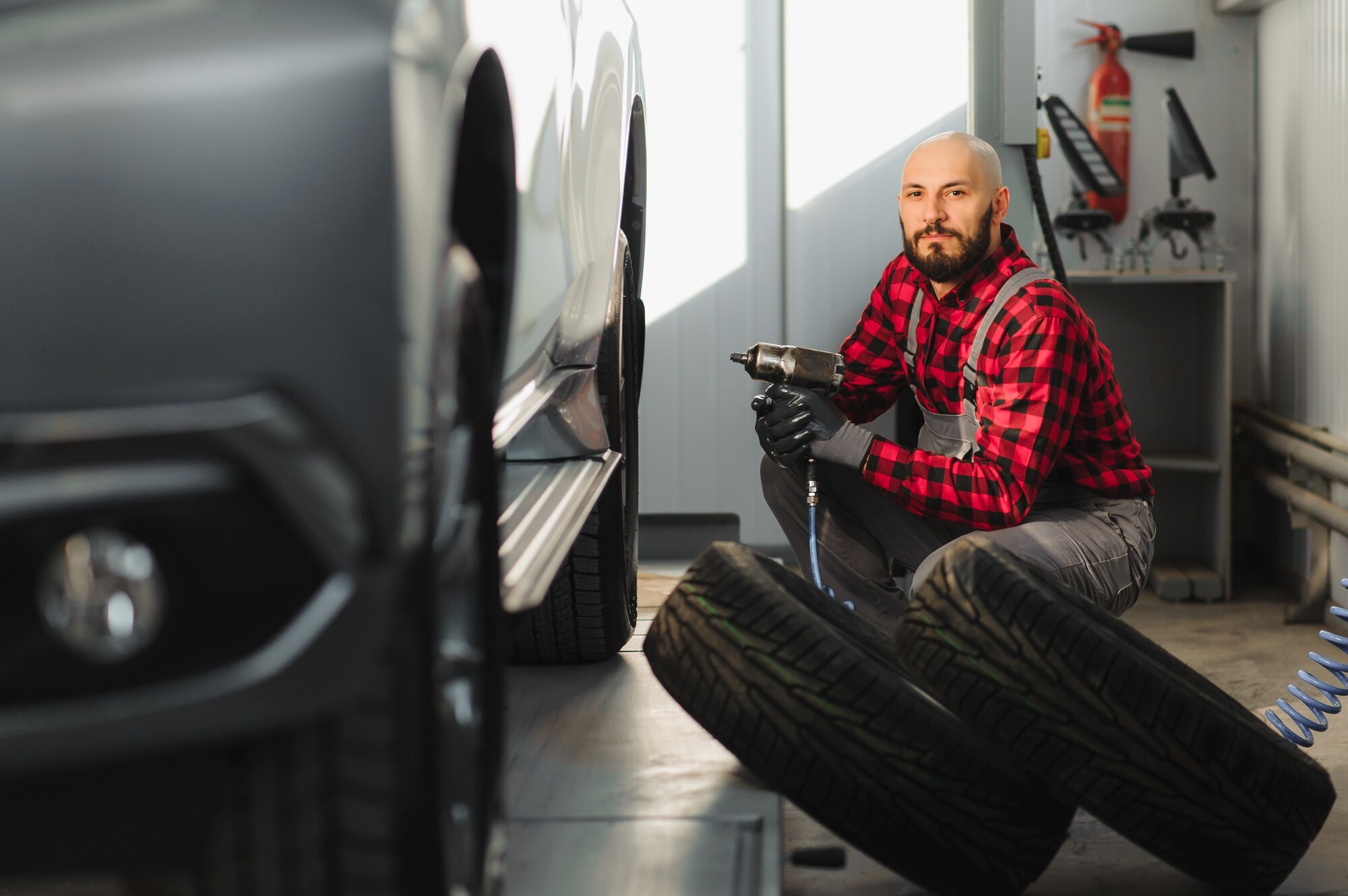 Mechanik zmienia oponę samochodową w warsztacie