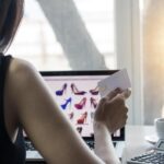 Środkowa część kobiety robiącej zakupy online na laptopie