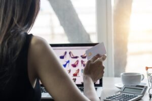 Środkowa część kobiety robiącej zakupy online na laptopie