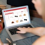 Młoda kobieta korzystająca z laptopa z kartą kredytową do bankowości internetowej, zakupów online, handlu elektronicznego za pomocą bramy płatniczej online w domu, nowoczesnych i wygodnych zakupów online z kartą debetową Blithe