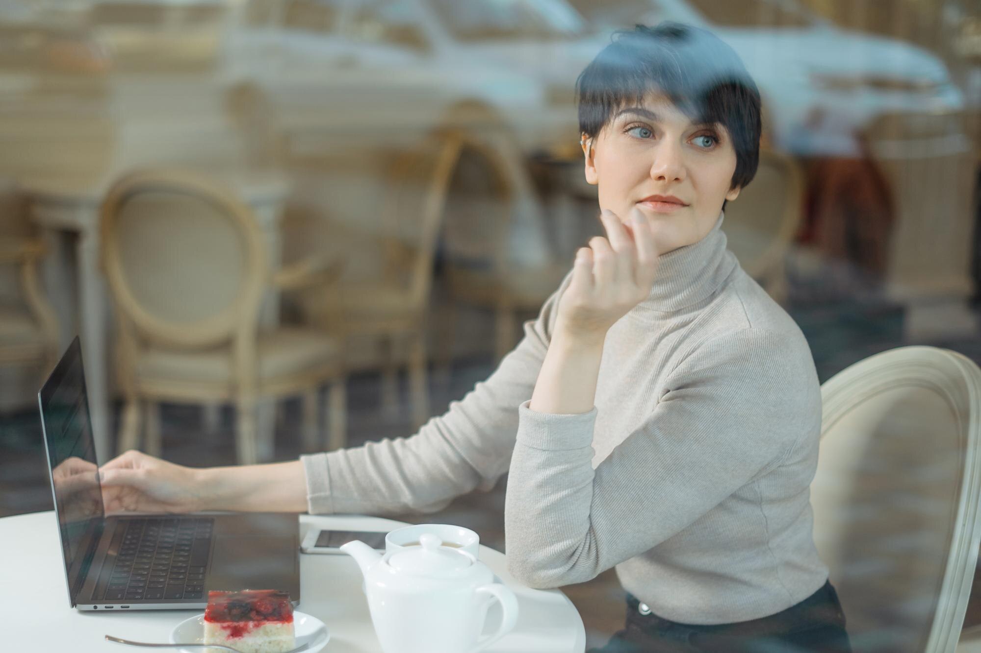 Portret kobiety siedzącej na stole w kawiarni