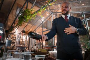 Pewny siebie kelner prezentujący wino w luksusowej restauracji
