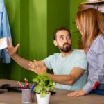Dwóch kolegów rozmawia twarzą w twarz. Przed komputerem