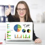 Bizneswoman pokazuje raport finansowy na laptopie w biurze