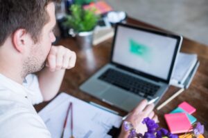 Kaukaski mężczyzna pracuje na laptopie siedząc w swoim nowoczesnym biurze Koncepcja młodych ludzi korzystających z miejsca coworkingowego
