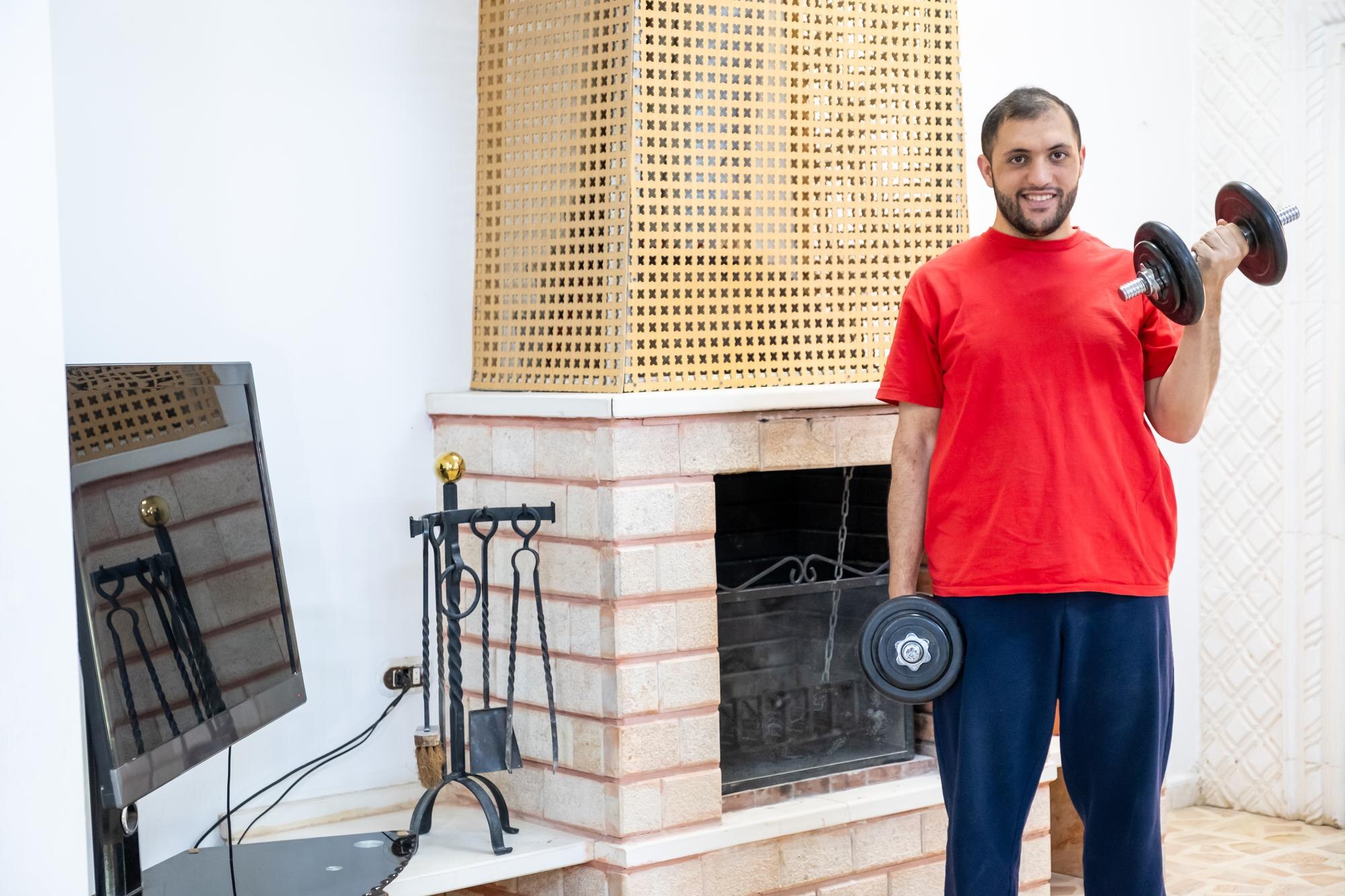Wysportowany facet ciężko trenujący w swoim domu