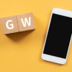 Drewniane klocki z tekstem koncepcji GW i smartfonem.