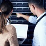 Zespół centrum danych i ludzi z inżyniera komputera przenośnego i przestrzeni makiety do współpracy jako sieć Technik z powrotem i sprzętu w serwerze do utrzymania aktualizacji systemu i bezpieczeństwa