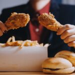 blisko skupienie kobieta ręcznie trzyma smażony kurczak dla eatgirl z koncepcją fast food