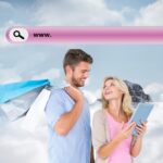 Atrakcyjna młoda para trzymająca torby na zakupy patrząca na komputer typu tablet przed szczytem górskim przez chmury