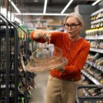 Woman shopping for kitchen supplies in a hardware store showcasing a decorative wire basket during her visit