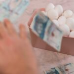 Mężczyzna liczy pieniądze w różowej misce z rachunkiem omani.