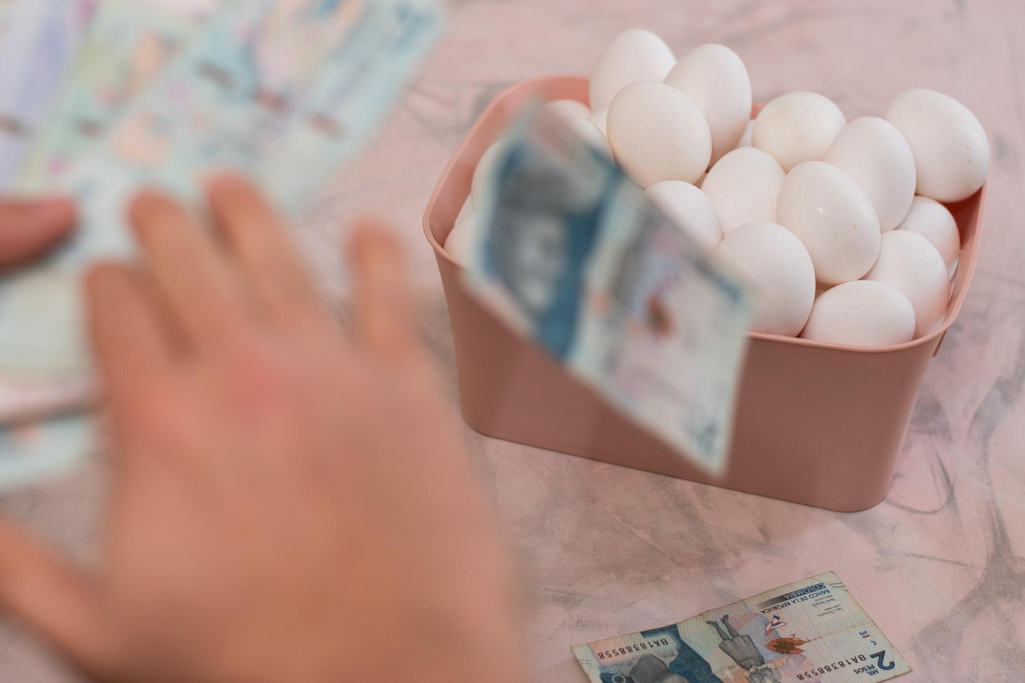 Mężczyzna liczy pieniądze w różowej misce z rachunkiem omani.