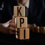 Biznesmen zrobił słowo kpi z drewnianymi elementami konstrukcyjnymi
