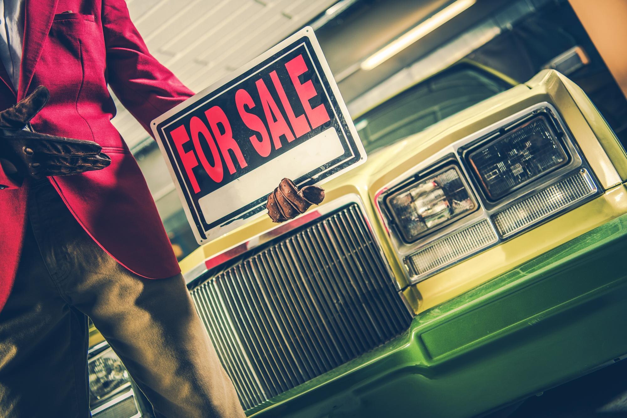 Znak "Auto na sprzedaż" w ręku