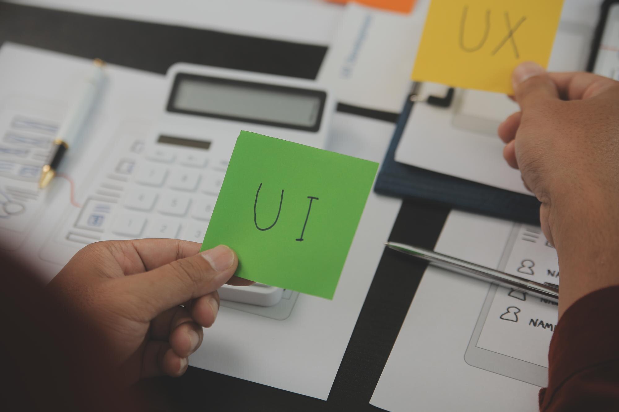 Close up ux developer i ui designer brainstorming o interfejsie aplikacji mobilnej wireframe design na stole z klientem breif i kod kolorowy w nowoczesnym biurzeCreative agencja rozwoju cyfrowego